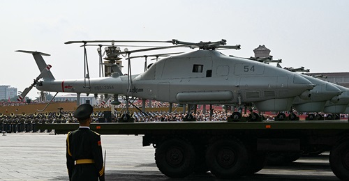 Photograph of multiple unmanned helicopters mounted on trucks during military parade