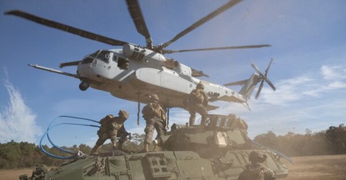 US Marines prepare to attach a light armoured vehicle (below) to a CH-53K at Camp Lejeune, North Carolina, on 19 November. The CH-53K is undergoing IOT&E to develop tactics, techniques, and procedures for its future use.