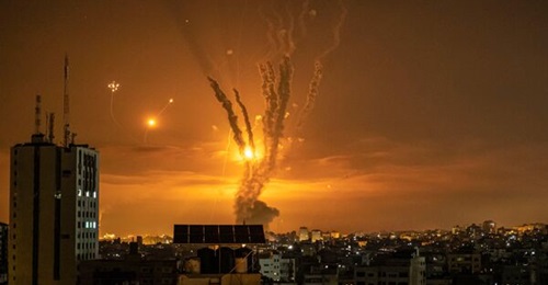 Rockets launched towards Israel from the northern Gaza Strip are targeted by Israel's Iron Dome missile defence system on 14 May 2021. The USMC is moving forward with a new initiative that will repackage the Iron Dome launcher on a trailer.