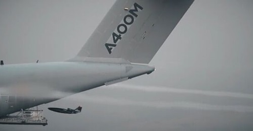 A screenshot from an Airbus video showing a conceptual Remote Carrier 'loyal wingman' separating from an A400M mother ship during testing.