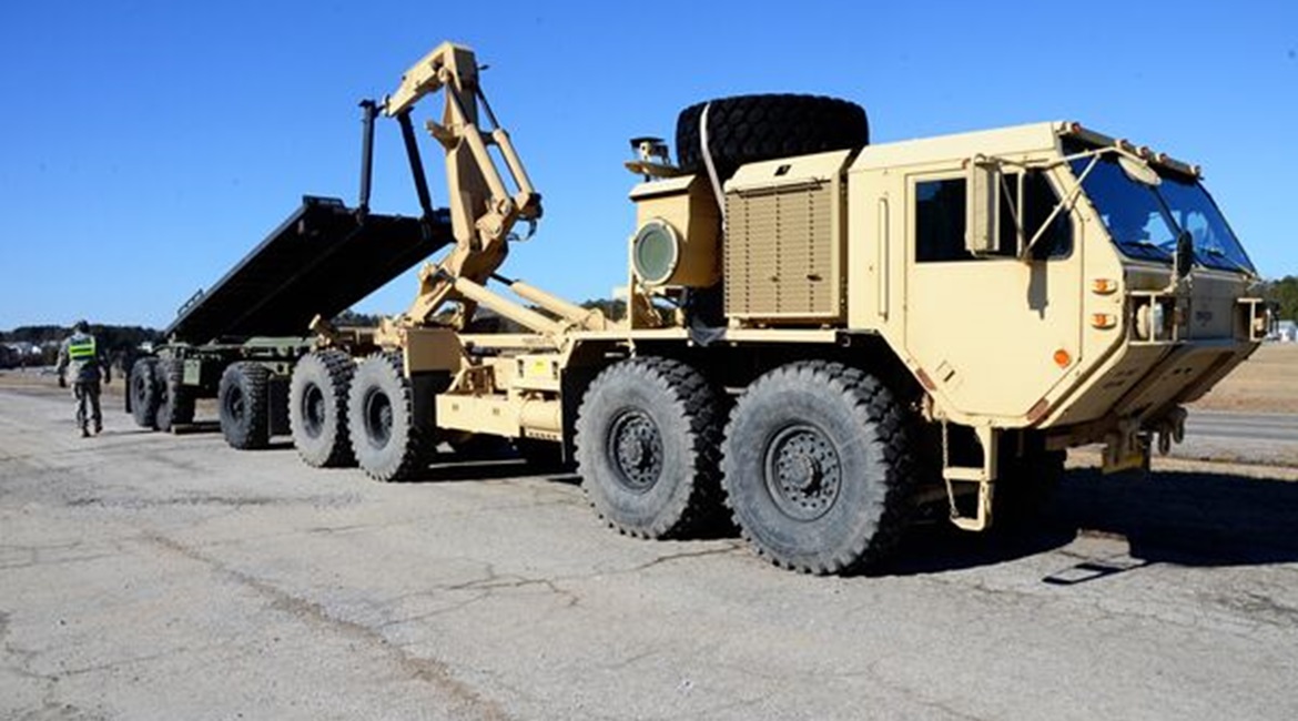 A HEMTT loads a flatrack on a PLS trailer. Kuwait has requested PLS trailers and flatracks but no HEMTT variants with the associated load-handling system.