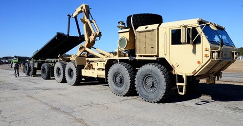 A HEMTT loads a flatrack on a PLS trailer. Kuwait has requested PLS trailers and flatracks but no HEMTT variants with the associated load-handling system.