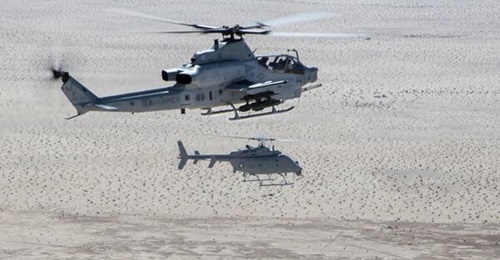 A US Marine Corps Bell AH-1Z attack helicopter seen operating in tandem with a US Navy MQ-8C unmanned helicopter.