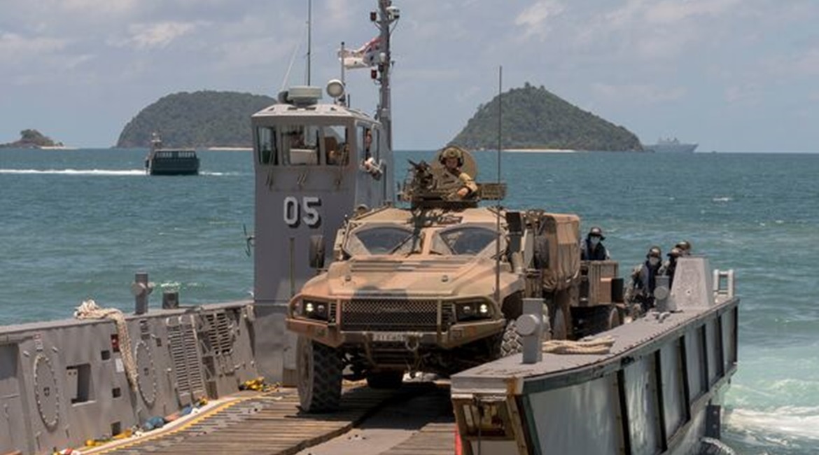 An Australian Army Hawkei PMV-L reverses onto a light landing craft from HMAS 
        
         at Cowley Beach in Queensland during Exercise 'Sea WADER 2020'. The DoD announced on 11 July that the Hawkei has achieved IOC.