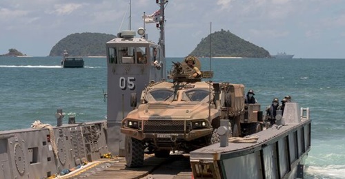An Australian Army Hawkei PMV-L reverses onto a light landing craft from HMAS 
        
         at Cowley Beach in Queensland during Exercise 'Sea WADER 2020'. The DoD announced on 11 July that the Hawkei has achieved IOC.