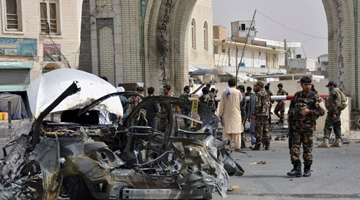 Afghan security forces personnel inspect the remains of a vehicle at the site of a bomb blast in Kandahar on 4 July. Although none of Afghanistan's 34 provincial capitals have fallen, the “strategic momentum” appears to currently be with th...