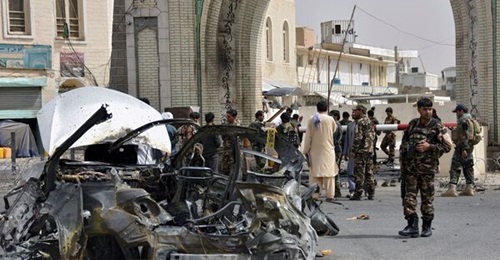 Afghan security forces personnel inspect the remains of a vehicle at the site of a bomb blast in Kandahar on 4 July. Although none of Afghanistan's 34 provincial capitals have fallen, the “strategic momentum” appears to currently be with th...