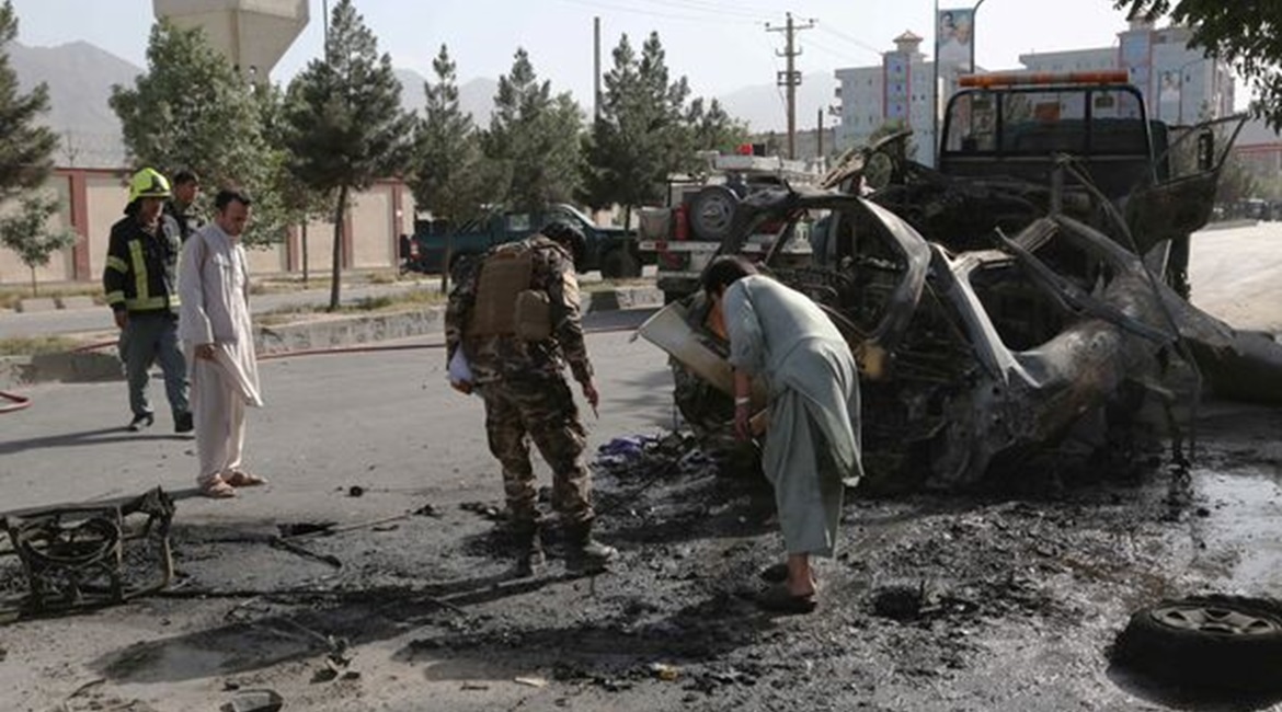 Afghan civilians along with security and emergency personnel inspect the remains of a vehicle at the site of a bomb blast in Kabul on 12 June. UNAMA reported on 26 July that the number of civilian casualties in Afghanistan increased 47% in the first ha...