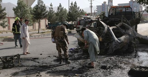 Afghan civilians along with security and emergency personnel inspect the remains of a vehicle at the site of a bomb blast in Kabul on 12 June. UNAMA reported on 26 July that the number of civilian casualties in Afghanistan increased 47% in the first ha...