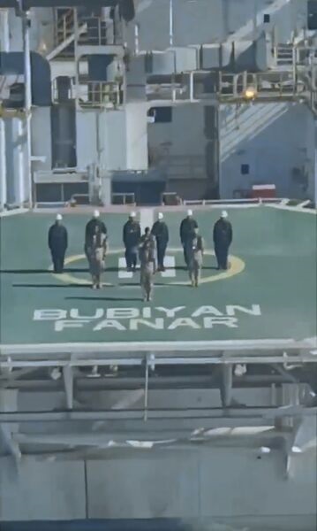 A still from a video clip released on 21 September 2021 shows personnel on the Bubiyan Fanar platform saluting as the Kuwaiti defence minister flies by in a helicopter.