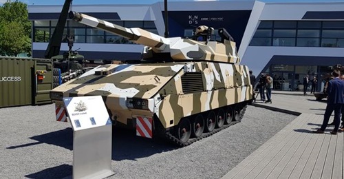 The front left view of KMW's tracked Boxer equipped with KMW's RCT120 unmanned turret mission module at Eurosatory 2022.