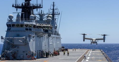 A USMC MV-22B Osprey prepares to land on the flight deck of HMAS 
        
         during flying operations at RIMPAC 2022.