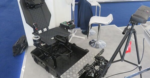 The Vrgineers portable reconfigurable flight trainer displayed at the Farnborough International Airshow 2022. The XTAL 3 HMD is on the top of the seat, with the tracking sensors shown as white dots. The infrared detector is mounted on the tripod.