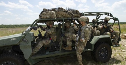 US Army infantry soldiers secure their rucks in the cargo netting on the roof of the ISV after it was airdropped at Fort Bragg during operational testing. The service announced it will outfit the ISV with a 20 kW-class laser to down unmanned aerial sys...