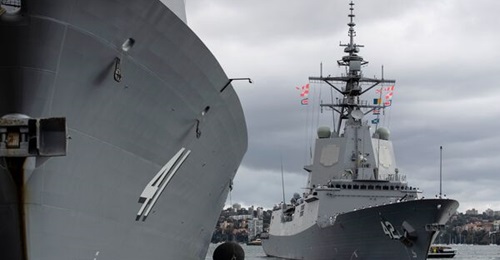 HMAS 
        
         (in the background) departing its home port at Fleet Base East, Sydney, on 11 March to trial its Aegis Weapon System with the US Navy.
