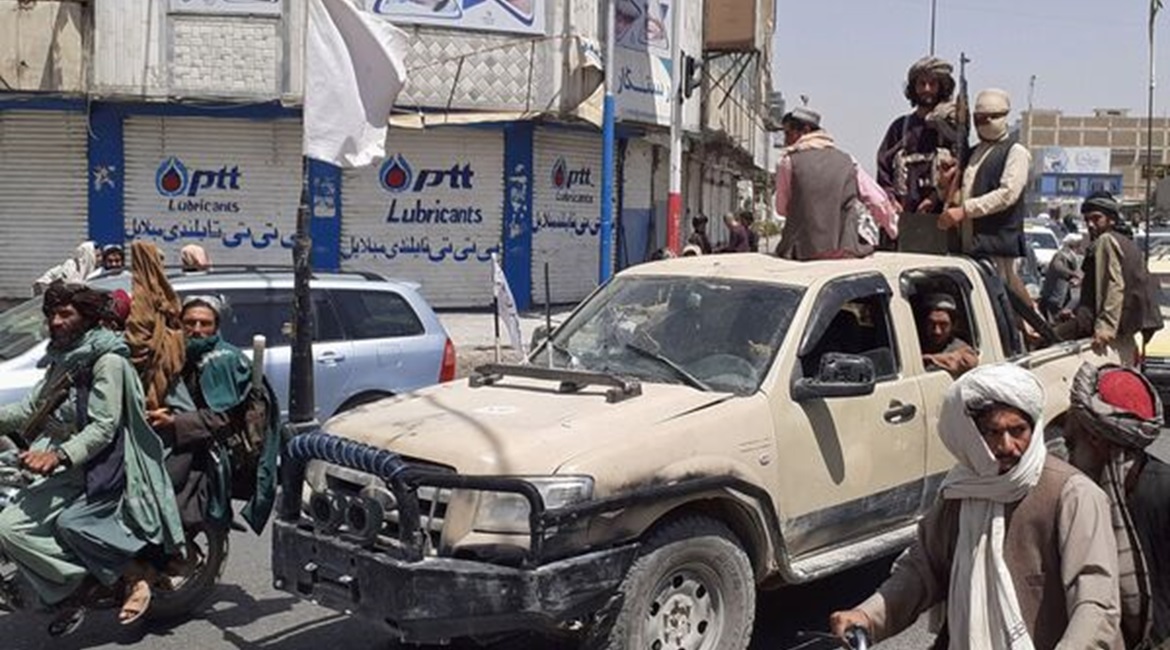 Taliban fighters drive an Afghan National Army vehicle through a street in Kandahar shortly after capturing the southern city on 13 August.