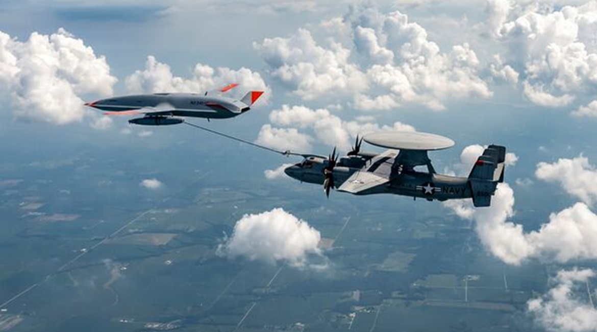A company-owned Boeing MQ-25A Stingray unmanned tanker passes fuel to a US Navy-operated E-2D Advanced Hawkeye receiver aircraft during trials.
