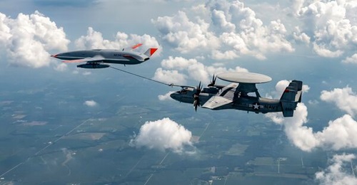 A company-owned Boeing MQ-25A Stingray unmanned tanker passes fuel to a US Navy-operated E-2D Advanced Hawkeye receiver aircraft during trials.