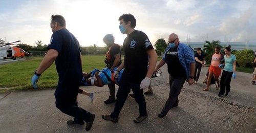 US Coast Guard Air Station Clearwater helicopter crew members assist a critically injured Haitian citizen on 18 August.