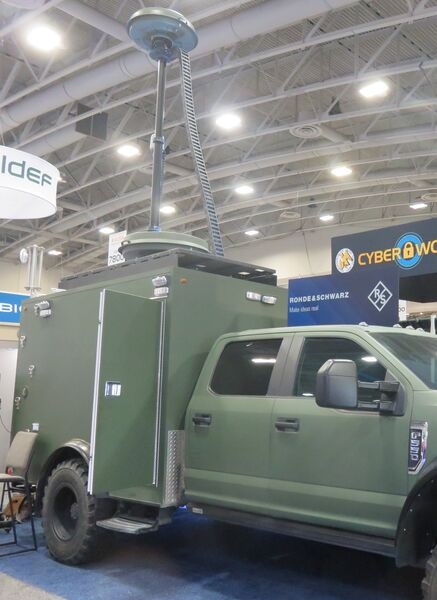 The Rohde & Schwarz SigBadger control vehicle displayed at AUSA 22, with its roof and mast-mounted ADDx multichannel DF antennas.