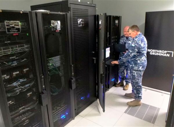 Flight Lieutenants Douglas Hogg and Davis Strauss from the ISR Transition Office at RAAF Base Edinburgh reviewing the Triton network configuration files on the newly delivered NITE. (Northrop Grumman)