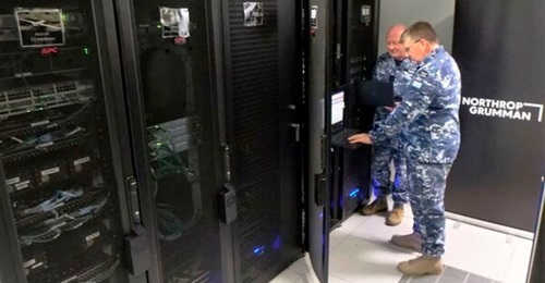 Flight Lieutenants Douglas Hogg and Davis Strauss from the ISR Transition Office at RAAF Base Edinburgh reviewing the Triton network configuration files on the newly delivered NITE.
