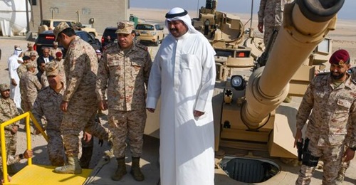 Kuwaiti Minister of Defence Sheikh Abdullah Ali al-Abdullah al-Sabah stands on an M1A2K.