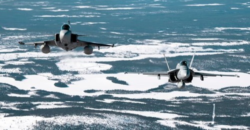 A Swedish Gripen and Finnish Hornet combat aircraft conducting joint manoeuvres. Together with Denmark and Norway, the two countries will combine their combat aviation assets with a joint Nordic operational concept agreed upon in a letter of intent.