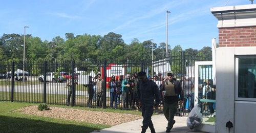 Role players pretend to protest outside a building in Camp LeJeune, North Carolina. The protesters simulated tensions in a foreign country that could lead to a non-combatant evacuation of the building, which represented a consulate in the 26th MEU's tr...