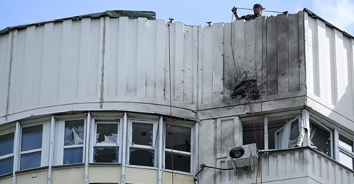 A specialist prepares a rope to inspect the damaged facade of a multistorey apartment building after a 'drone' attack in Moscow on 30 May.