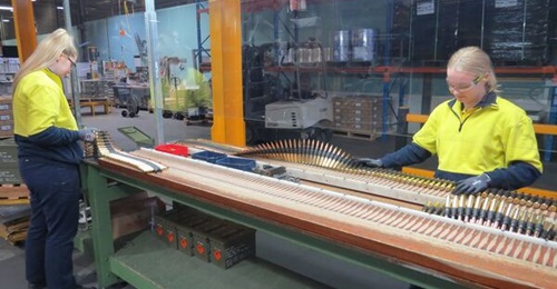 Thales Australia employees conduct the final visual inspection of .50 calibre ball linked ammunition on the production line at Benalla.