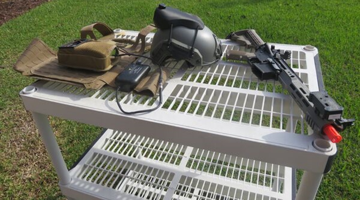 The components of Lockheed Martin's SIMRES geo-pairing system: player unit, helmet sensor, and weapon sensor mounted on the barrel of an Airsoft weapon that was being used for demonstration purposes.