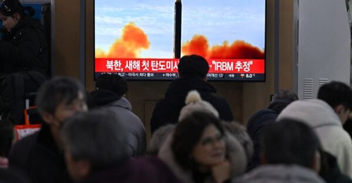People watch a television screen showing a news broadcast with file footage of a North Korean missile test, at a railway station in Seoul on 14 January. North Korea was said to have fired a ballistic missile that day and this was confirmed by Pyongyang...