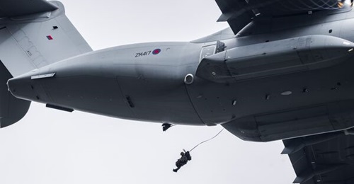 A paratrooper exits one of the two side doors of the A400M during a demonstration of the aircraft's low-level parachuting capabilities.