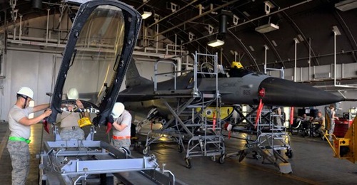 USAF personnel conduct localised maintenance of a Lockheed Martin F-16 at Misawa Air Base, in Japan, in 2014. In this image, personnel are preparing to install a canopy on the aircraft.
