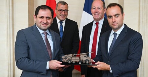 French Minister of the Armed Forces Sébastien Lecornu (right) hands a model of a CAESAR to Armenian Minister of Defence Suren Papikyan.