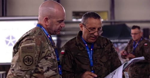 Colonel Ryan Kendall, commander of the 12th CAB, speaks with his Polish counterpart at the first US-Polish Apache Initiative summit.