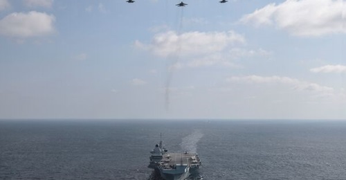 Aircraft participating in the maiden UK-India bilateral tri-services exercise 'Konkan Shakti-21' fly in formation over the UK Royal Navy carrier HMS 
        
         during the military manoeuvres.