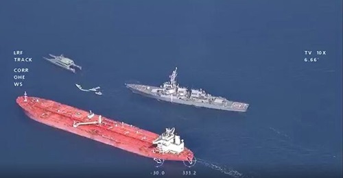 A still from the video shows the proximity of a USS destroyer to the tanker 
        
         and IRGC vessels that include the high-speed catamaran
