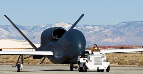 A nose view of the RQ-4 Global Hawk Block 20 AV 04 2015 that shows the types enlarged under fuselage sensor housing and the provision for SIGINT antennas built into both sides of its forward fuselage.