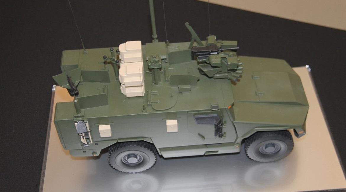 A scale model of Serval fitted with a roof-mounted remote weapon station at the front, acoustic detection system, situational awareness system, counter-improvised explosive device equipment, and pintle-mounted machine gun.