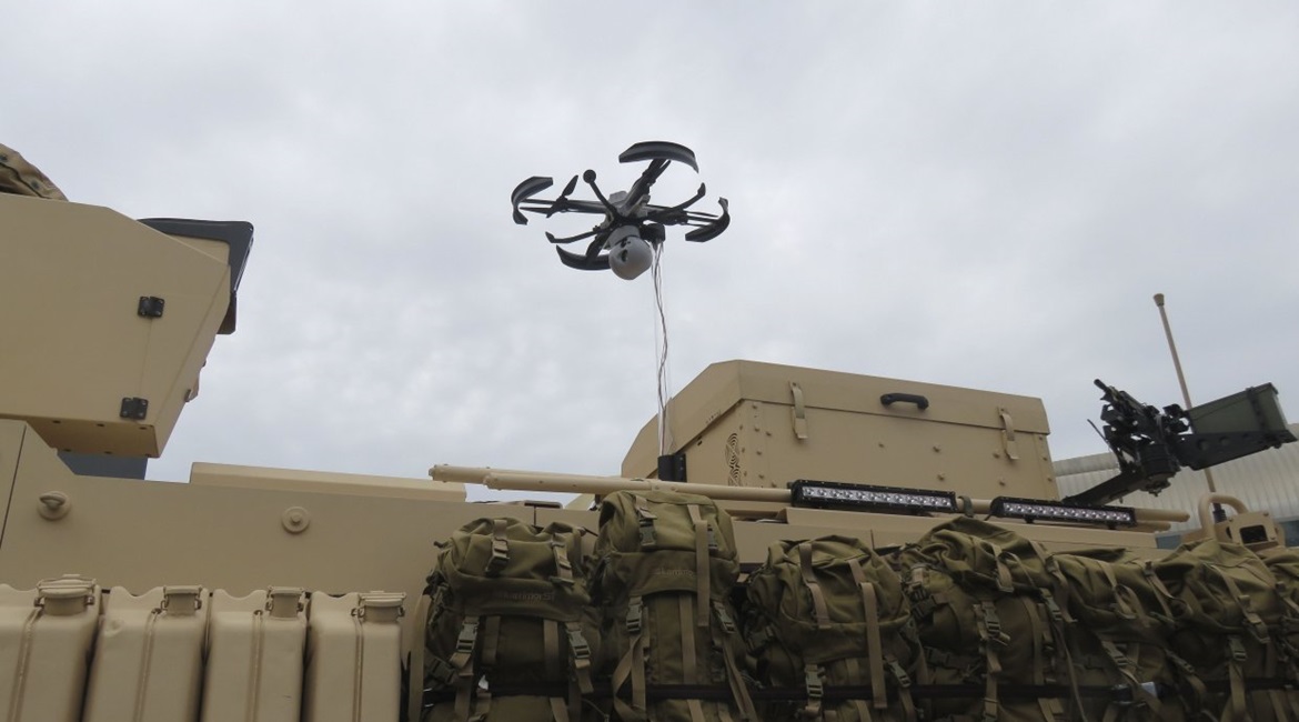 The Nexter Robotics FINDEAGLE IXOS XX tethered UAS displayed above a Titus armoured vehicle at IDEX 2019.