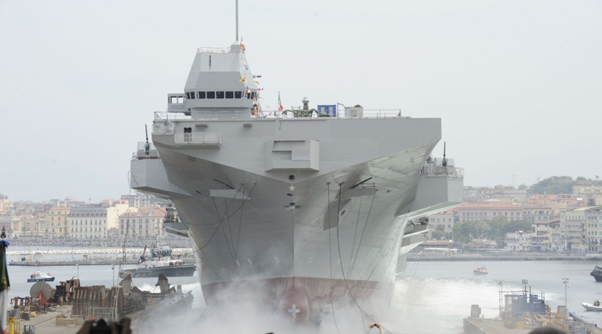 The LHD 
        
         during its launch. Note the limited space between the shipyard and Castellammare port's pier: just 450 m for a 214 m hull length, which required specific arrangements to increase hull friction in the water.