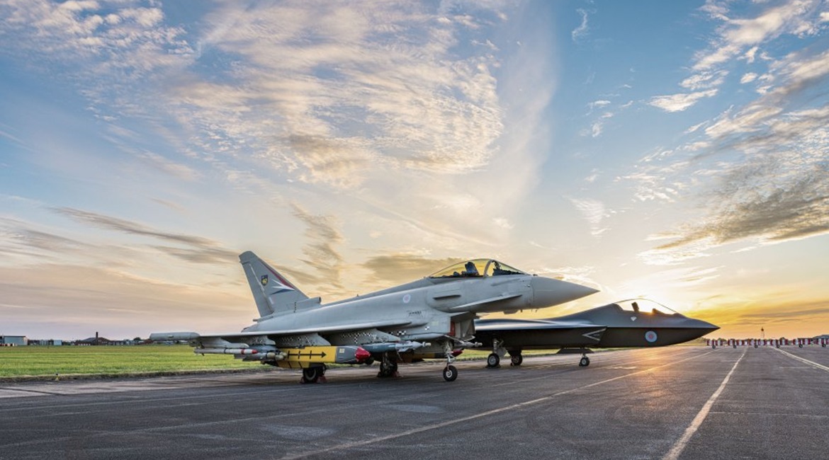 A Eurofighter Typhoon sits alongside a concept model of Tempest, a vision of the UK's future combat aircraft, at BAE Systems' site in Warton, Lancashire.