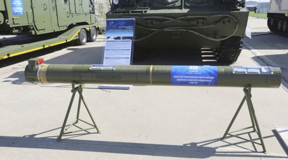 A 9M338KE surface-to-air guided missile displayed in its container in front of a Tor-E2 tracked combat vehicle at the MAKS 2019 International Air Show.