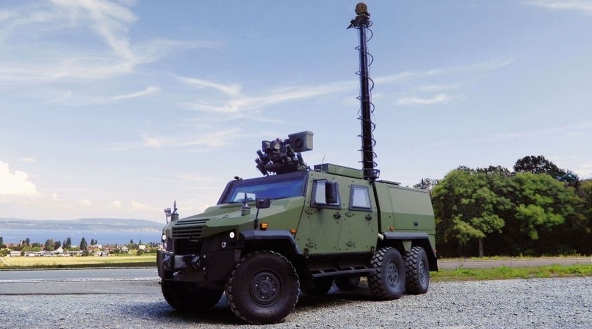 An Eagle 6×6 developed to meet Swiss army requirements, showing a protected four-door compartment, mast-mounted sensor pack, and Kongsberg remote weapon station.