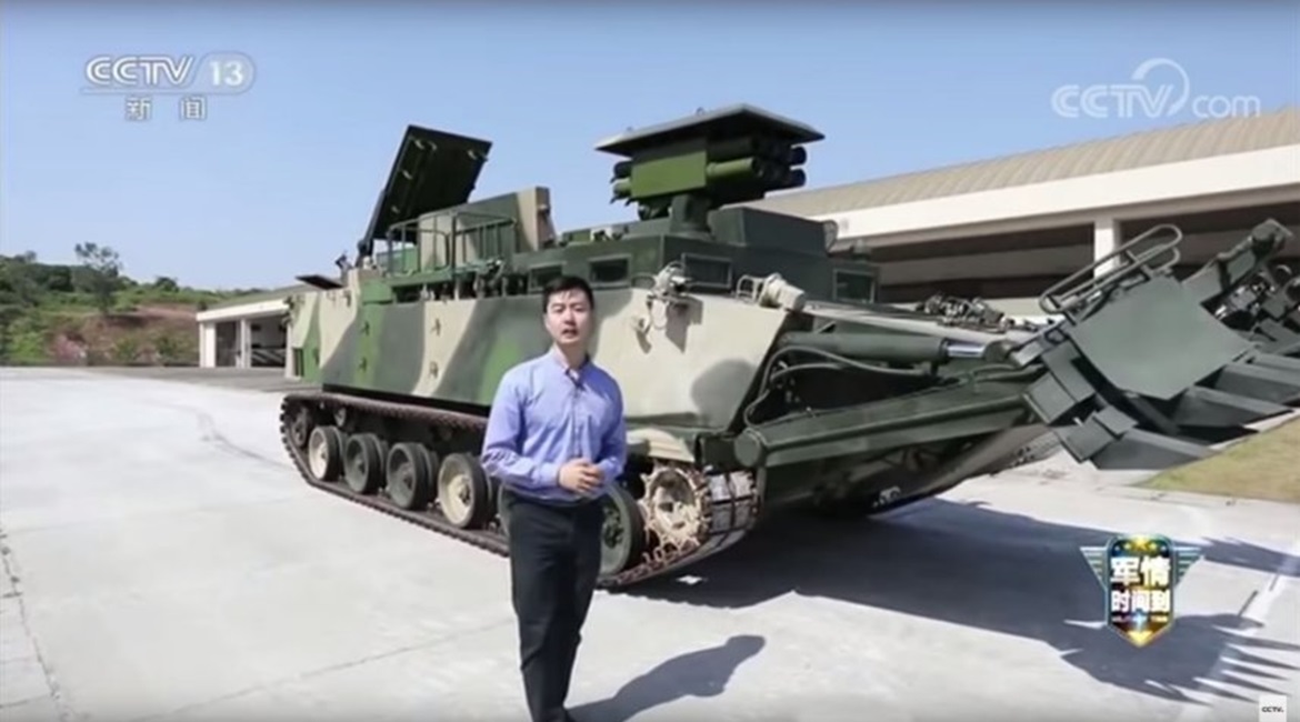 A still from a CCTV-13 video showing the PLANMC's new armoured breaching vehicle (background). The platform carries an array of systems designed to ensure that a force can move through obstacles as quickly as possible.