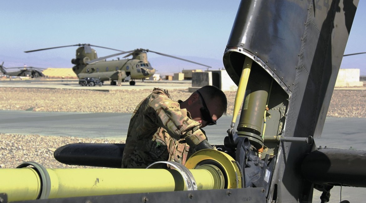 A US Army maintainer works on the drive chain of an Apache helicopter. The US DoD is looking to upgrade the tail-rotor systems of the Apache and other helicopters to cope with the increased power of the ITEP engine soon to be installed.