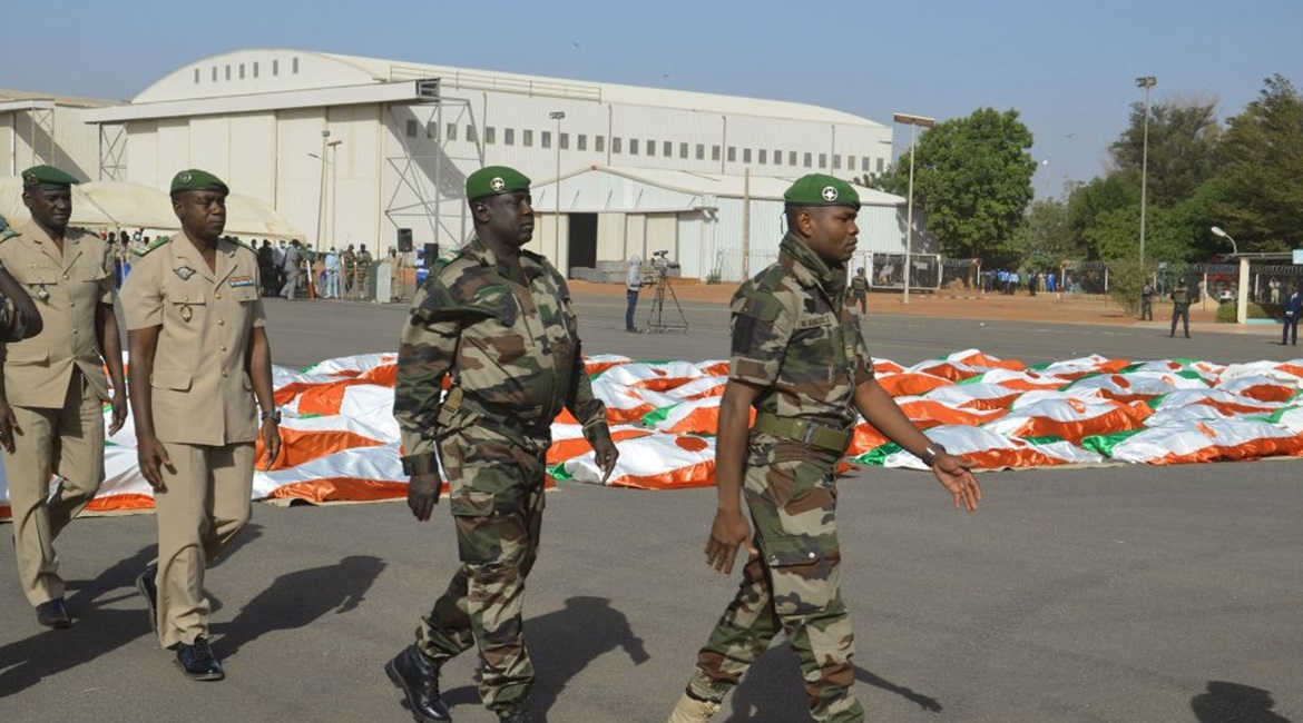 Nigerien military personnel walk past the corpses of soldiers killed in a 10 December 2019 attack on a military base in western Niger.