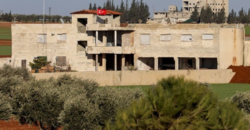 A Turkish flag flies over a building with a Turkish armoured vehicle parked outside north of Saraqib on 1 February.